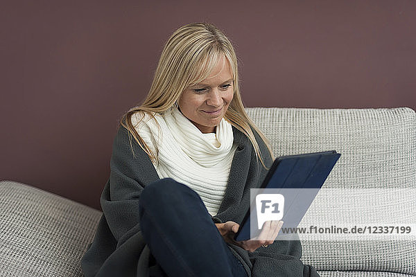 Woman sitting at home  reading e-book