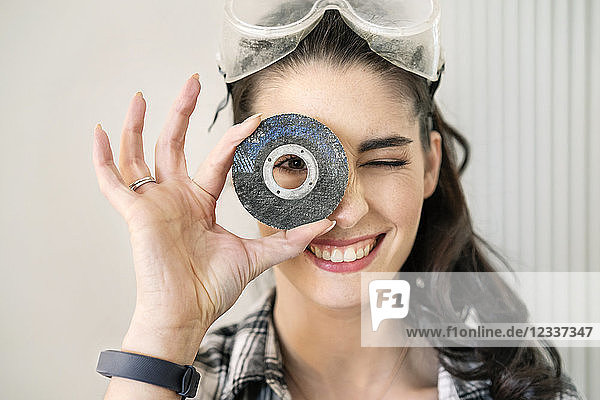Young woman renovating her new flat  looking through grinding disc