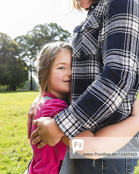 Daughter hugging mother in a park