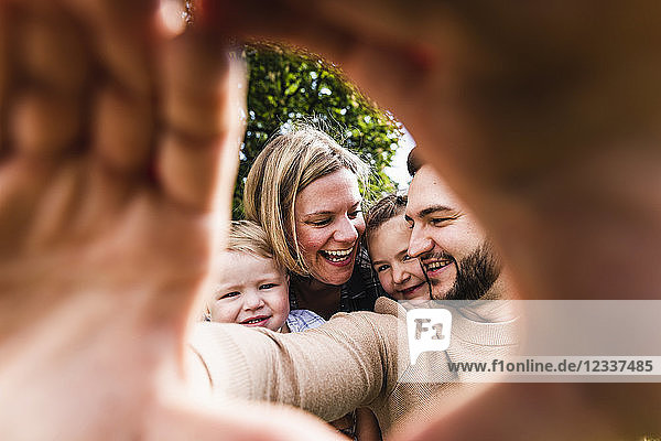 Happy family behind finger frame