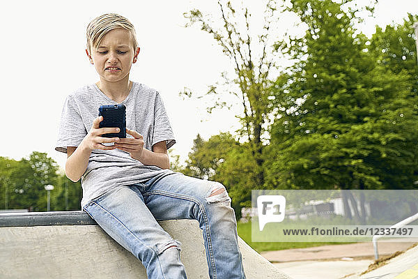 Boy finding something disgusting on smartphone