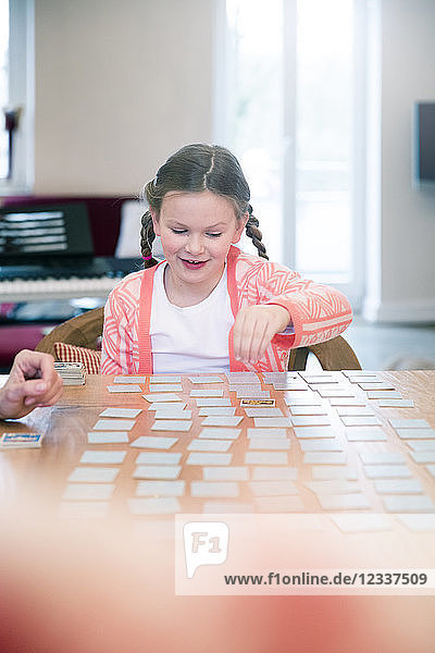 Girl playing memory on table at home