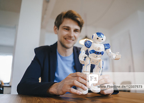 Smiling man holding robot
