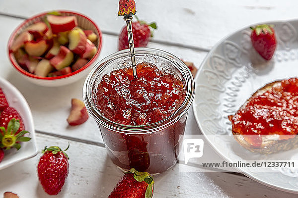 Glass of strawberry rhubarb marmelade on breakfast table