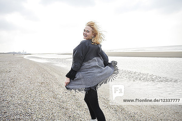 Netherlands  portrait of laughing blond young woman on the beach
