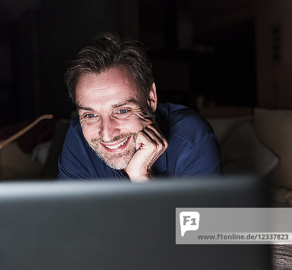 Portrait of smiling man looking at laptop having fun