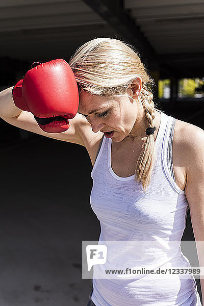 Woman with boxing gloves looking tired