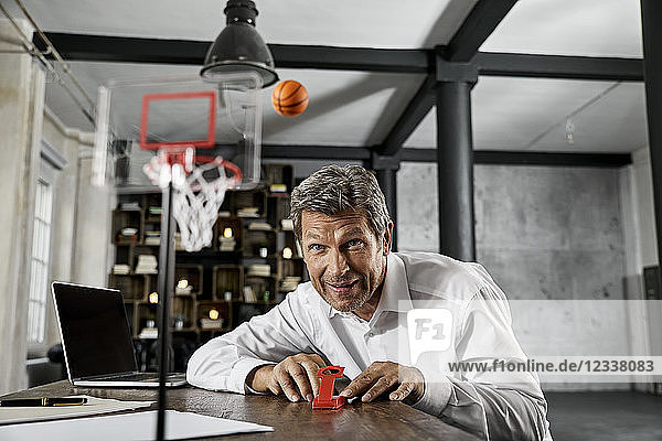 Portrait of mature business man playing office games in loft
