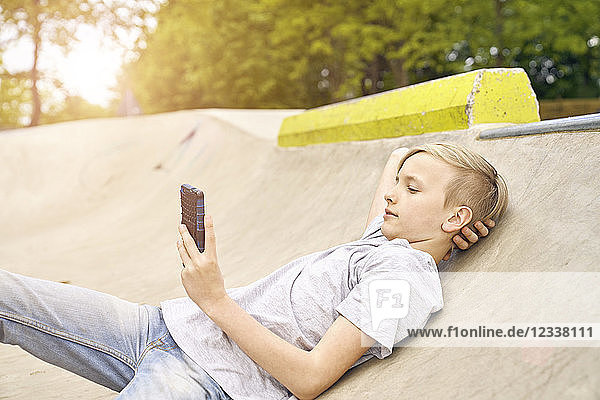 Boy using smartphone in skatepark