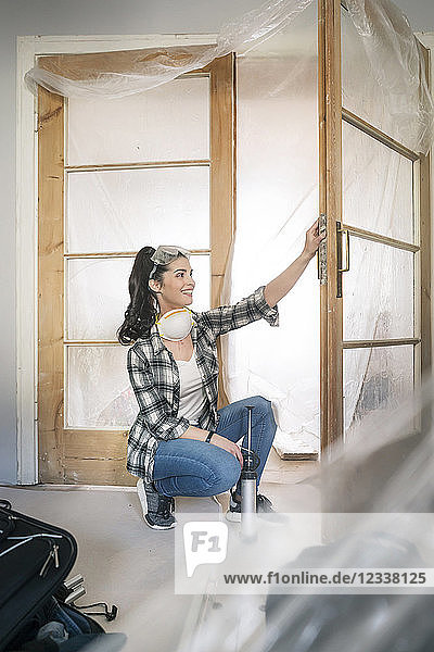Young woman renovating her new flat  examining door
