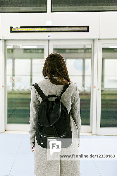 Back view of woman with black backpack