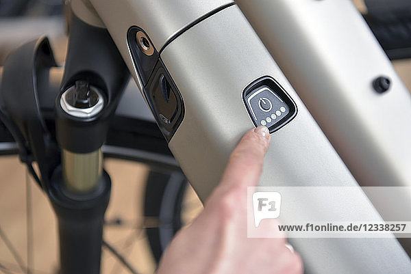 Finger pointing on switch of an e-bike