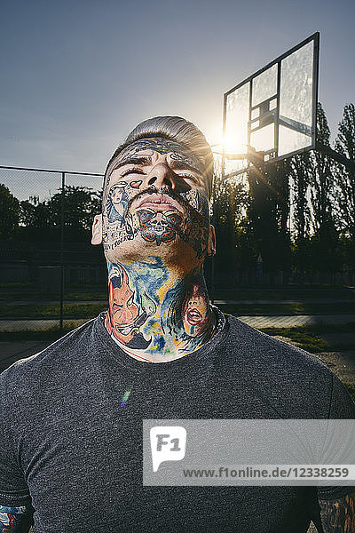 Portrait of tattooed young man on basketball court