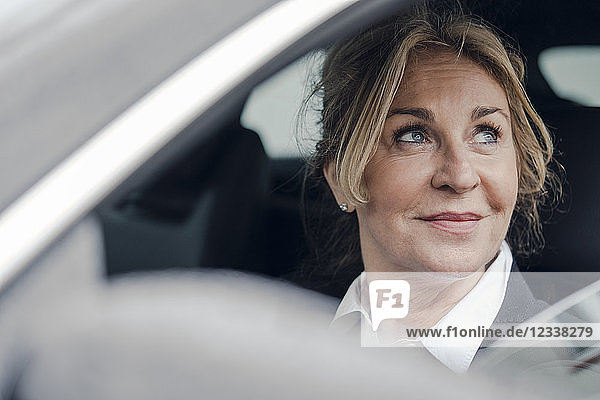 Portrait of smiling senior businesswoman in car