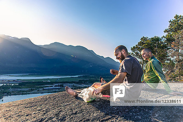 Freunde entspannen sich auf einem Bergabhang mit Blick auf den See  Squamish  Kanada
