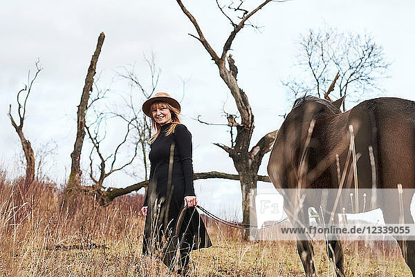 Porträt einer Frau mit Pferd  die lächelnd in die Kamera schaut
