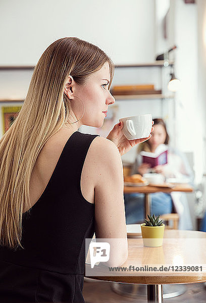 Young woman having coffee in cafe