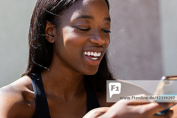 Young woman smiling at text on mobile phone