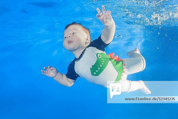 5 months boy swim underwater in the pool.