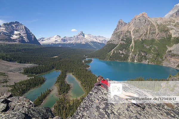 Female hiker enjoying view from high lookout on lake ohara. Lake O`Hara area Yoho National Park British Columbia Canada.