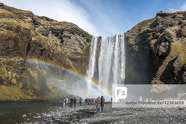 Menschen am Wasserfall Skogafoss mit Regenbogen  Skogar  Südisland  Island  Europa