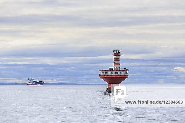Lighthouse Phare du Haut-Fond Prince in Saint Lawrence River with freighter in the back  Tadoussac  Québec Province  Canada  North America