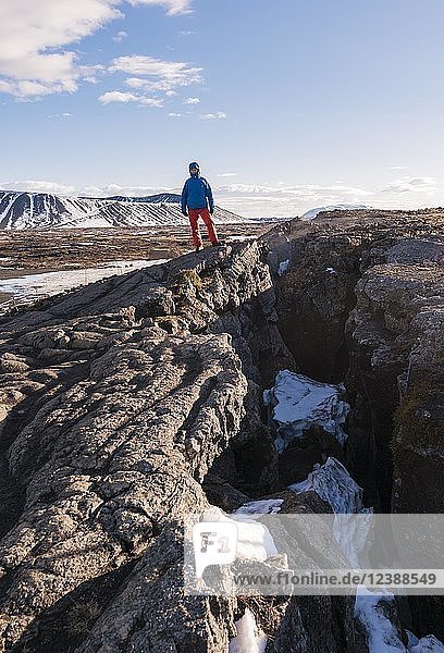 Man stands at Continental Rift between North American and Eurasian Plate  Mid-Atlantic Ridge  Rift Valley  Silfra Rift  Krafla  North Iceland  Iceland  Europe