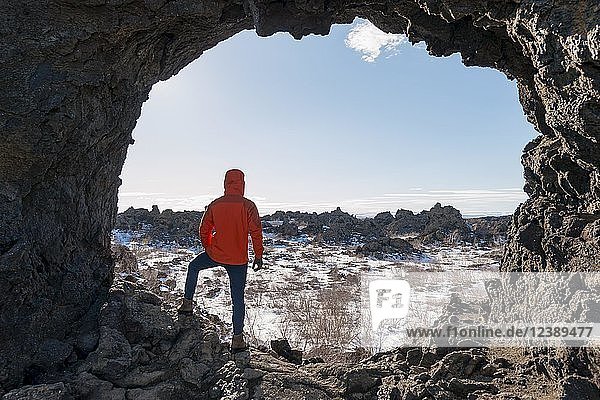 Man in a rock arch  volcanic landscape  Krafla volcanic area  Dimmuborgir National Park  Mývatn  Iceland  Europe