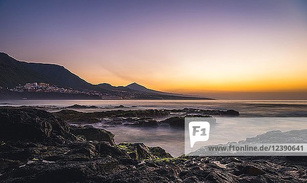 Felsenküste und Meer bei Sonnenuntergang  hinter Bajamar und Vulkan Pico del Teide  Punta del Hidalgo  Teneriffa  Kanarische Inseln  Spanien  Europa