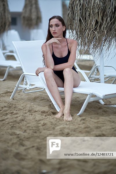 Greece  Crete  Malia  model woman sitting on sunbeds