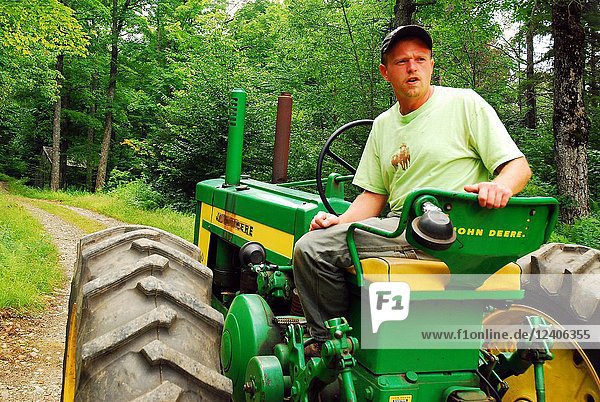 An adult man drives his tractor during a tour of his farm in Wilmington  Vermont.