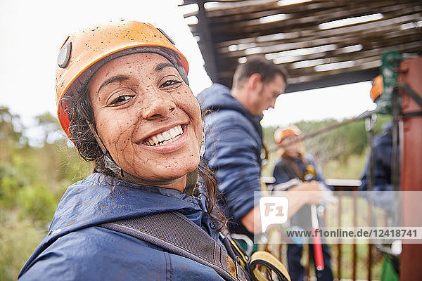 Portrait enthusiastic  muddy young woman enjoying zip lining