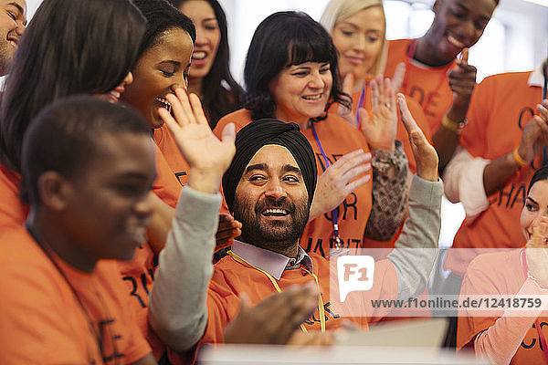 Happy hackers cheering and celebrating  coding for charity at hackathon