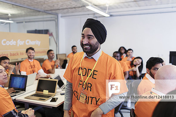 Happy  confident hacker in turban coding for charity at hackathon