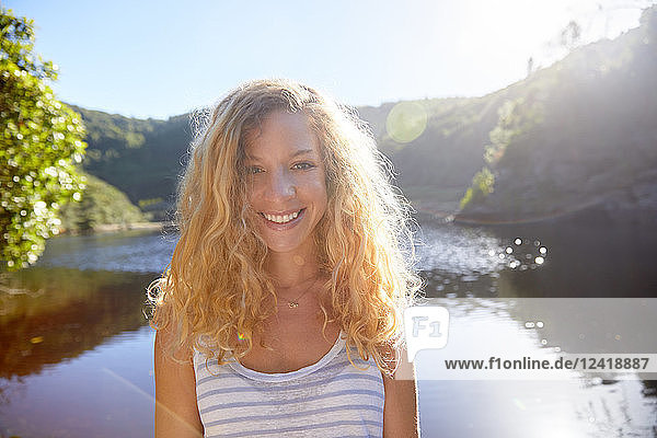 Portrait smiling  confident young woman at sunny summer lake