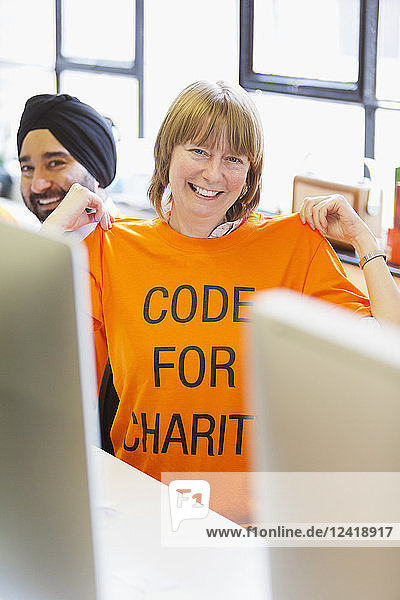 Portrait confident hacker wearing t-shirt  coding for charity at hackathon