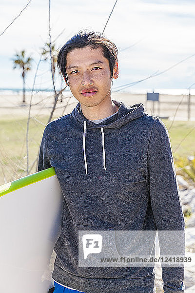 Portrait confident male surfer with surfboard