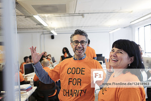 Enthusiastic hackers coding for charity at hackathon