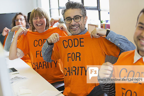 Portrait confident hackers in t-shirts coding for charity at hackathon