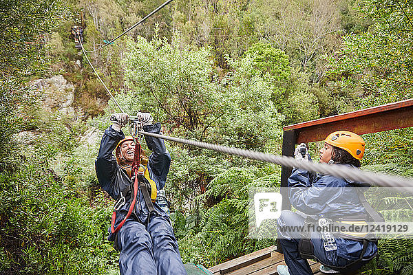 Woman zip lining above trees