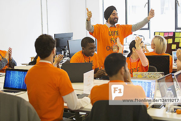 Hackers cheering  coding for charity at hackathon