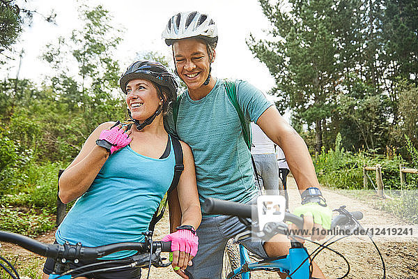 Happy  affectionate young couple mountain biking