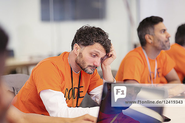 Focused hacker coding for charity at hackathon