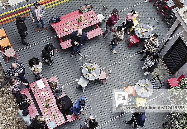 Overhead view friends socializing  drinking and eating at party on patio