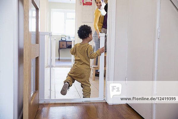 Cute baby boy balancing in doorway