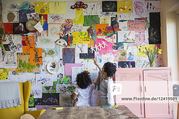 Kleinkind Bruder und Schwester hängen Kunst an der Wand