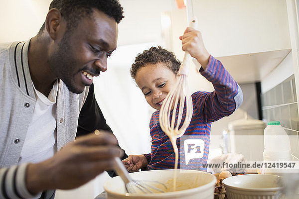Father and toddler son baking in kitchen