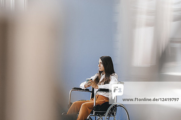 Young handicapped woman sitting in wheelchair  looking worried