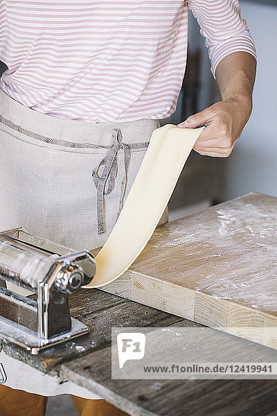 Woman preparing homemade pasta  using pasta maker