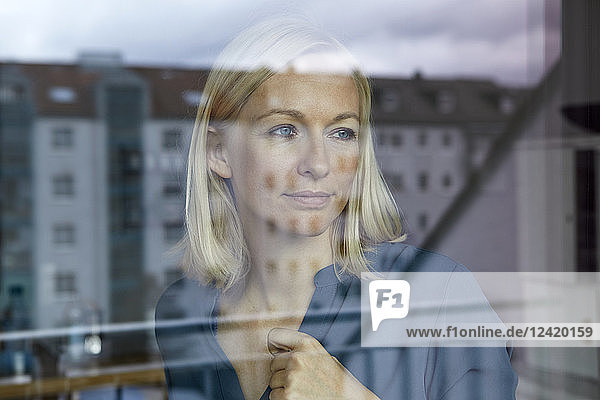 Blond woman looking out of window
